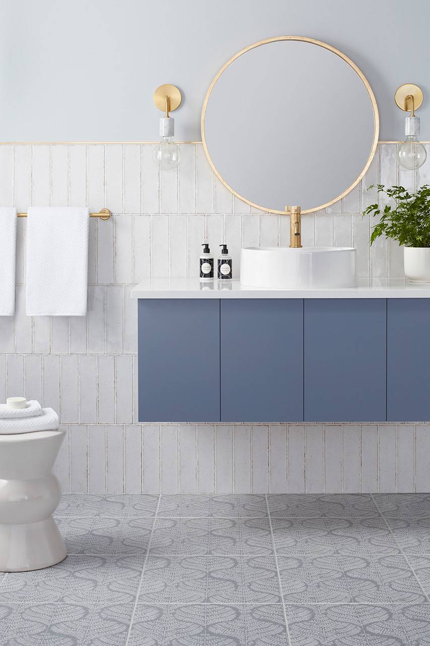 Bathroom with white subway tile wall and blue with white floral patterned floor tile.