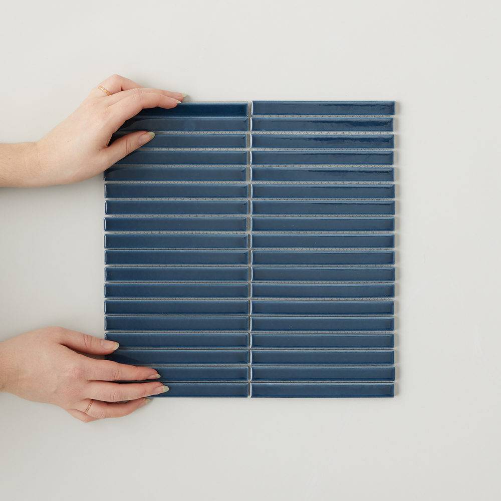 flatlay of navy blue tiled mosaic with hands