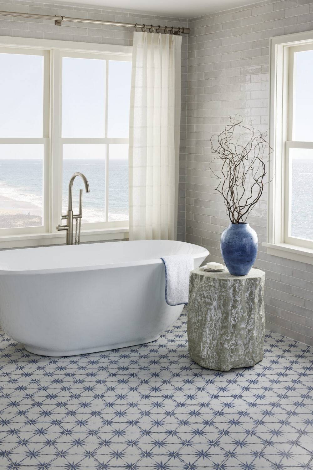 Coastal bathroom with blue and white patterned floor tile.