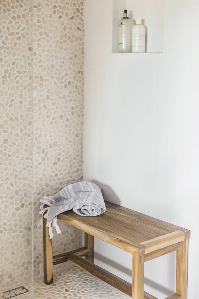 Rustic shower with beige pebble and stone tile.