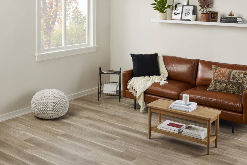 living room with brown leather couch and coffee table with vinyl flooring