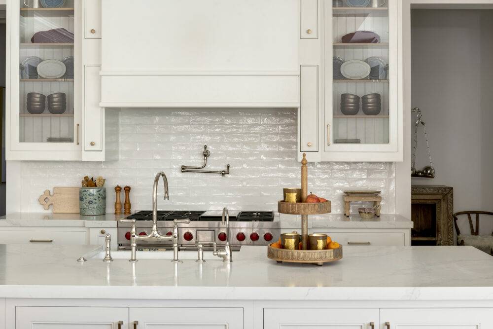 Kitchen with glass-paneled cabinets featuring Retro Lino subway and Retro Lino trim tile. 