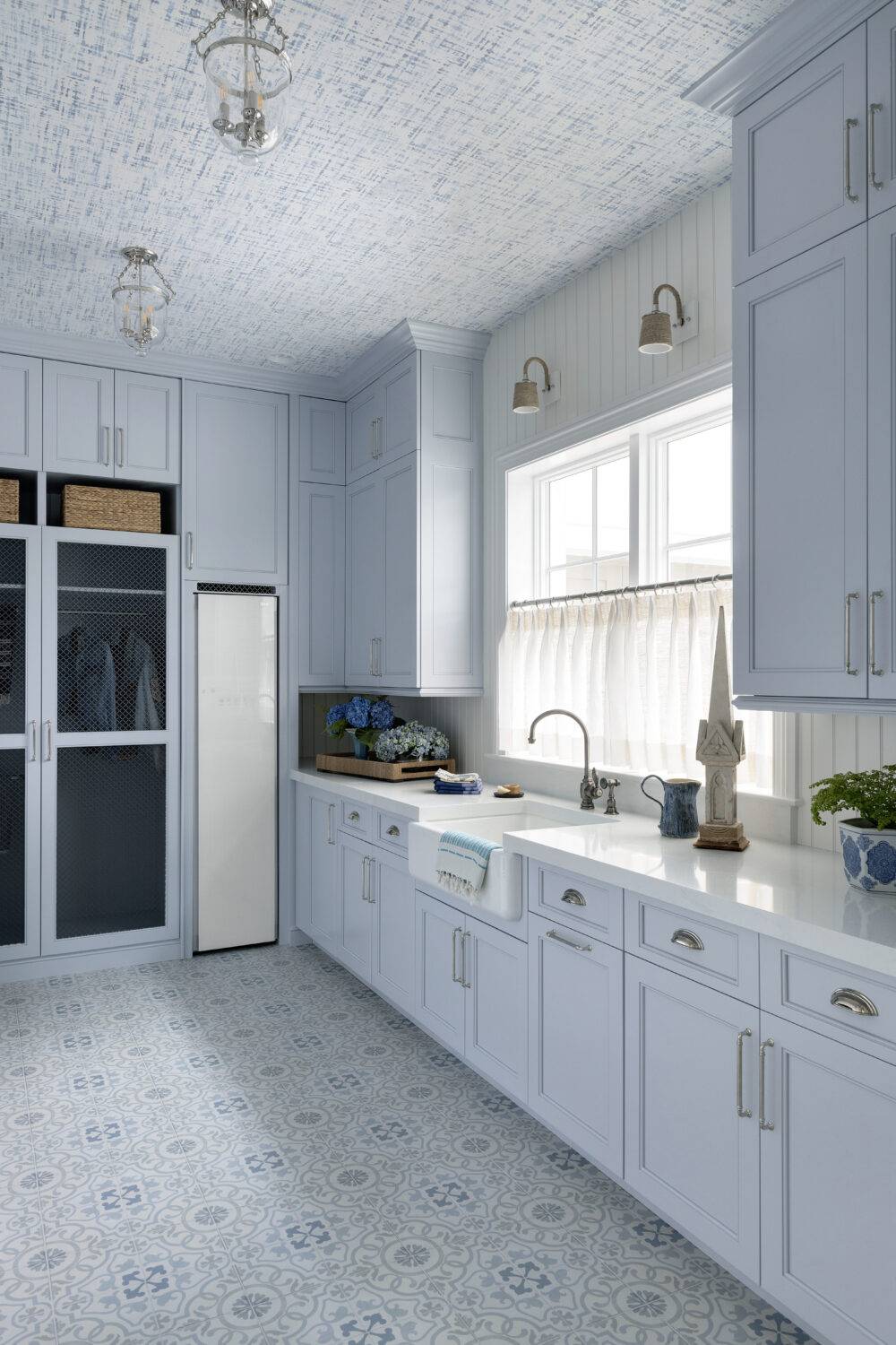 Laundry room with light-blue cabinets featuring Decora Ornament Blue and Annie Selke Crosshatch Sky tile.