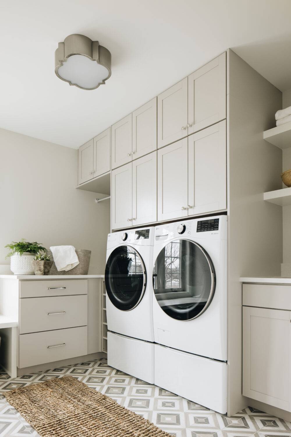 Beige and grey laundry room with grey square-patterned tile floor.
