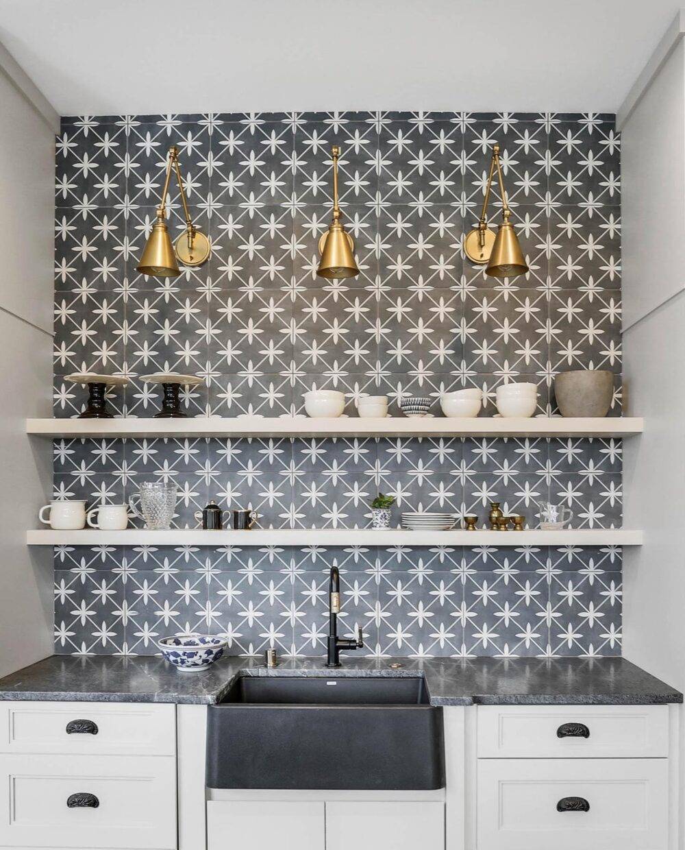 Bar area with black and white tile and gold light fixtures. 